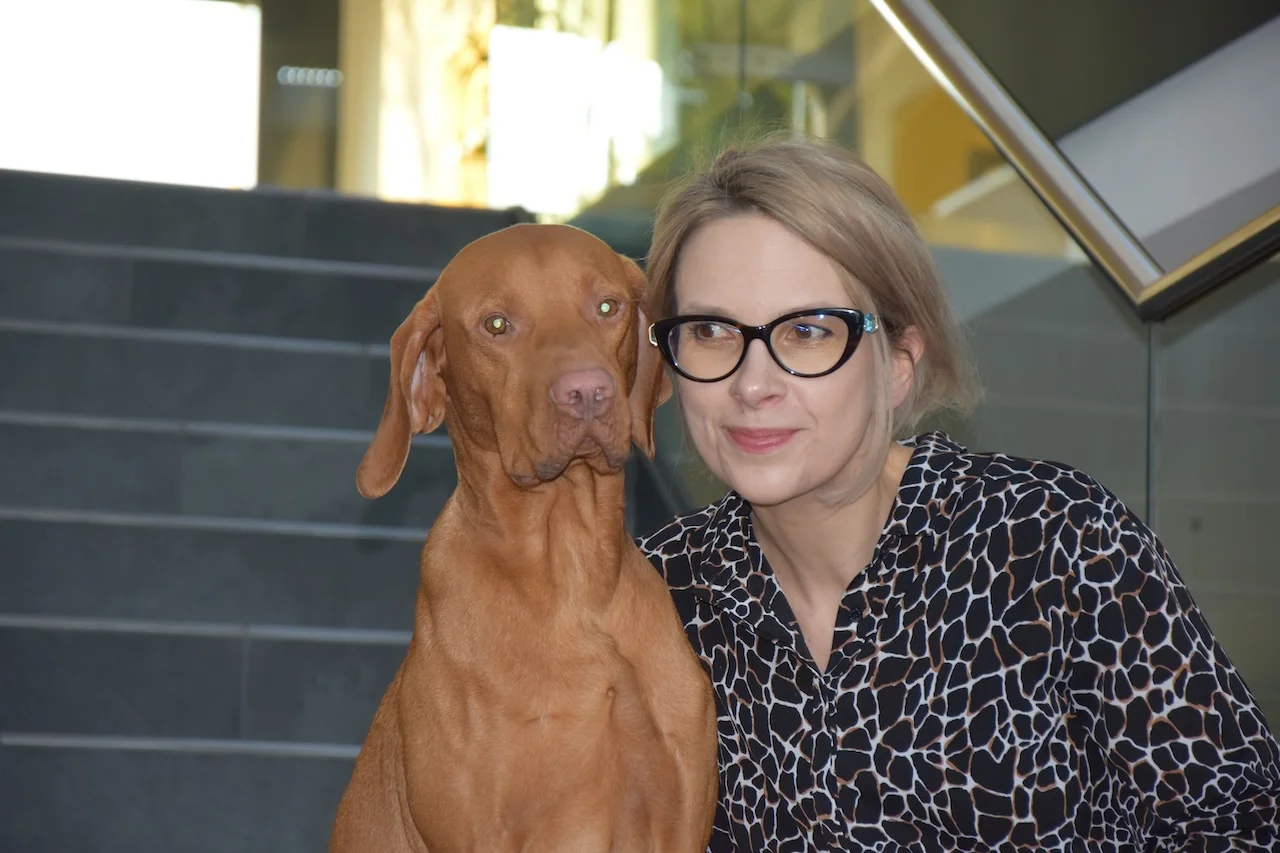 Radka Eder sitzt mit einem Hund auf einer Treppe